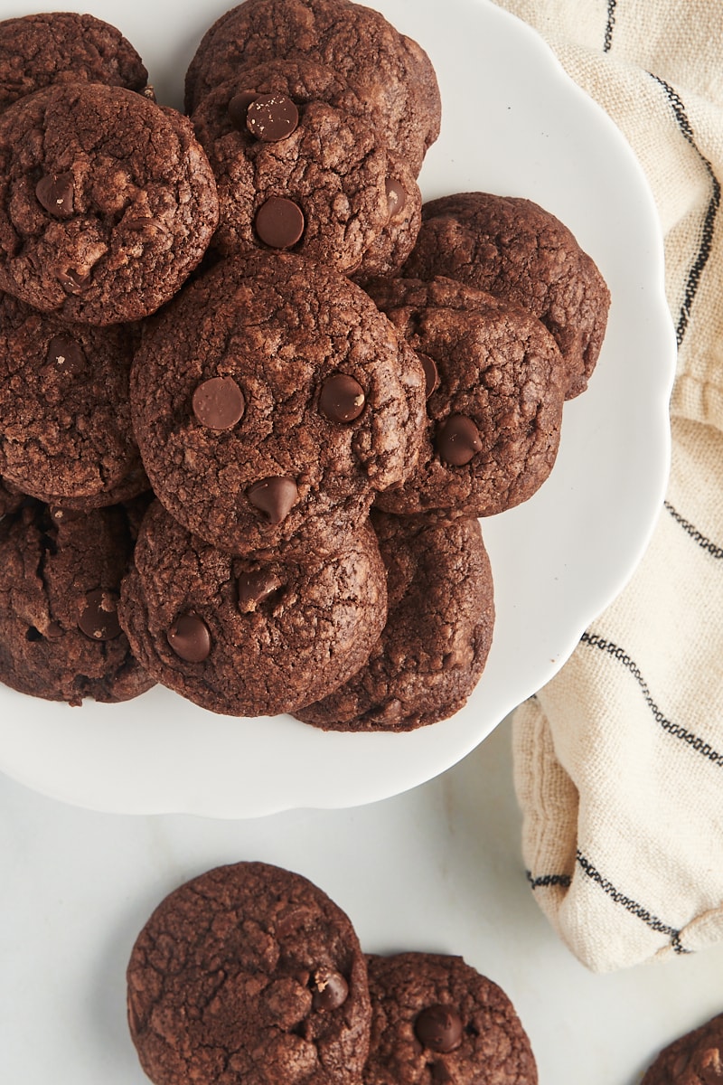 Overhead view of chocolate chocolate chip cookies on cake stand and countertop