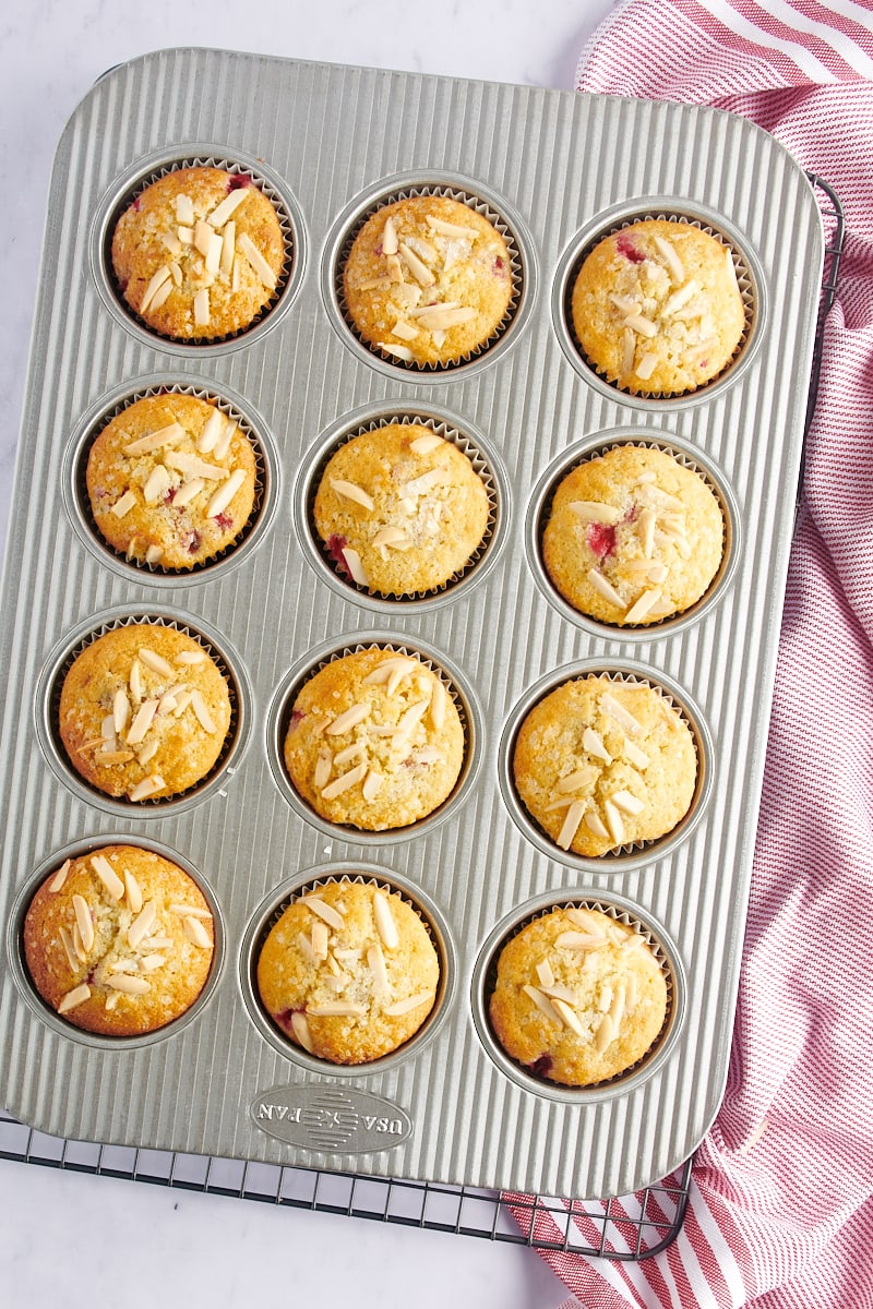 overhead view of freshly baked Red Currant Muffins in a muffin pan on a wire rack