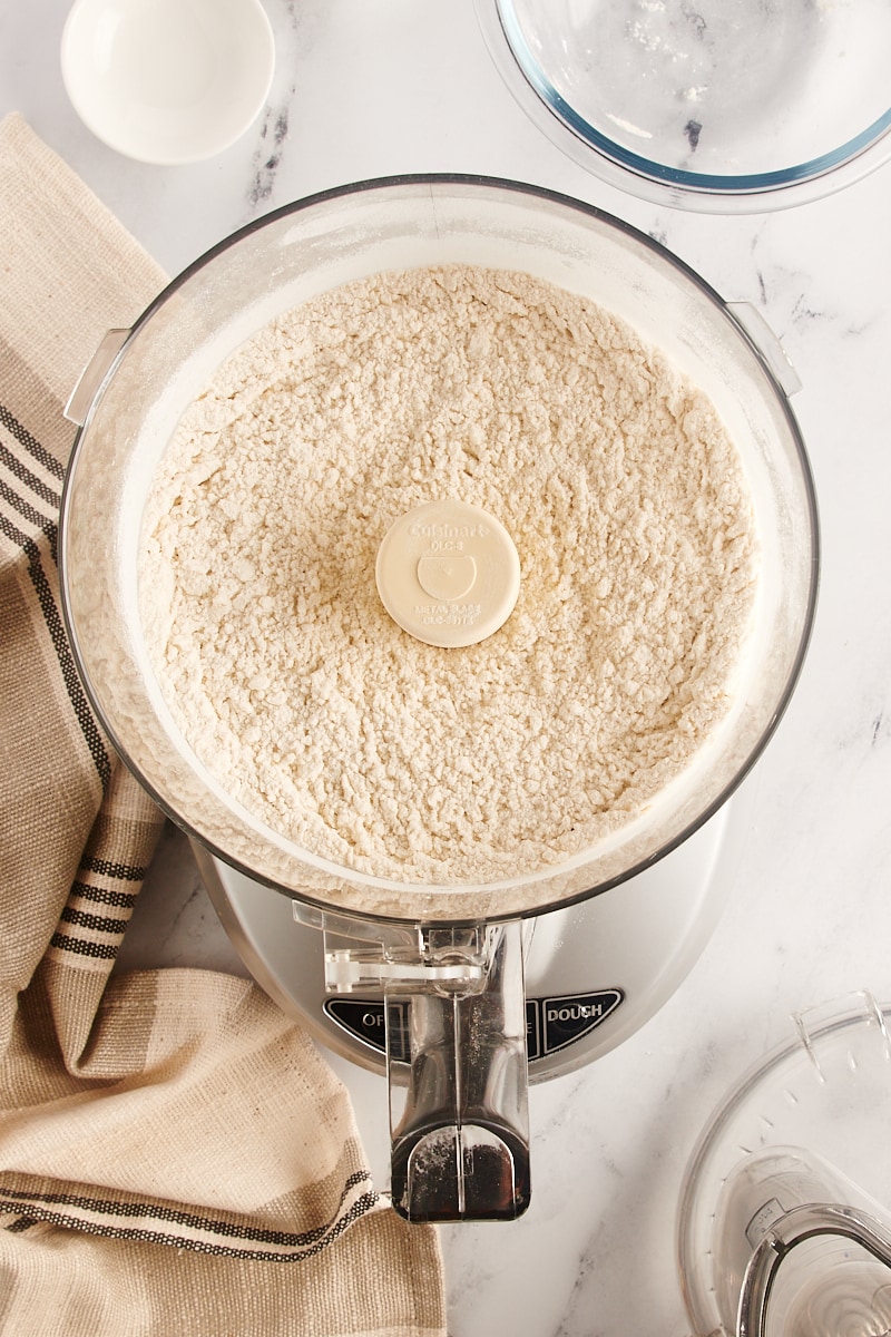 overhead view of combined dry ingredients for pie crust in a food processor