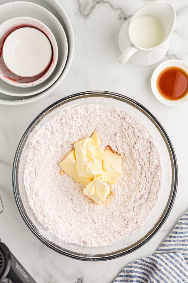 Overhead view of butter and dry ingredients in mixing bowl