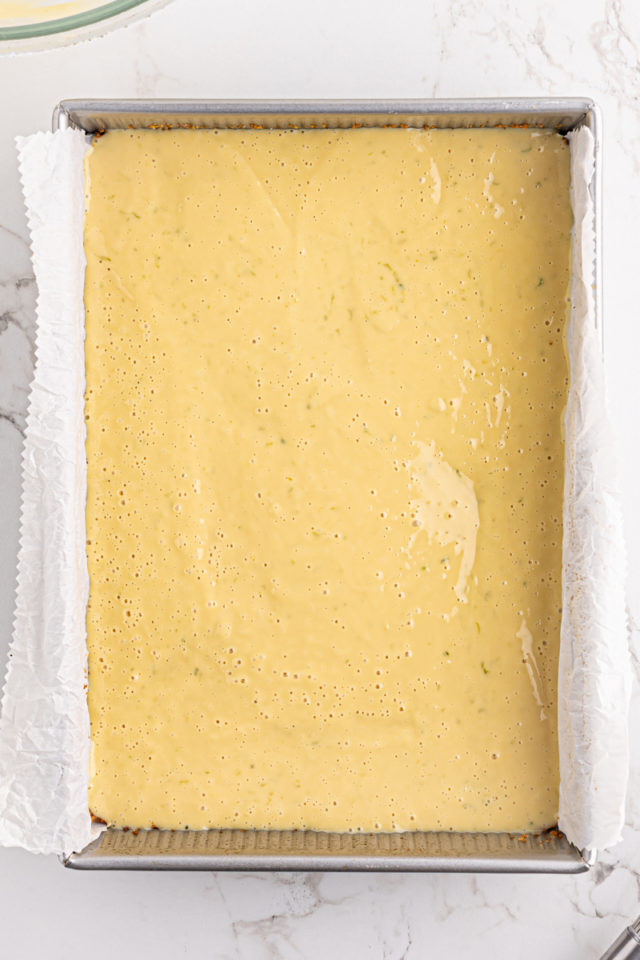 overhead view of key lime pie bars in a baking pan ready to go into the oven